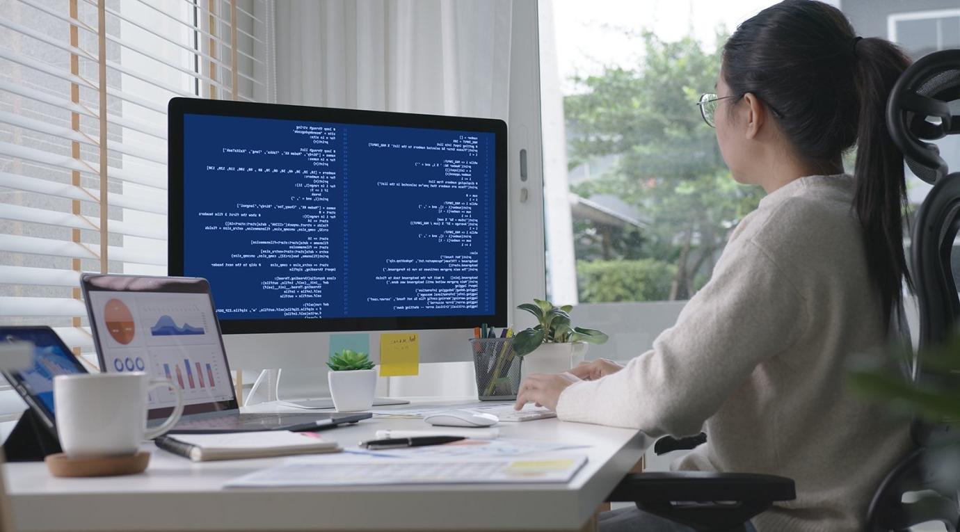 a student sits at a computer with code on the screen