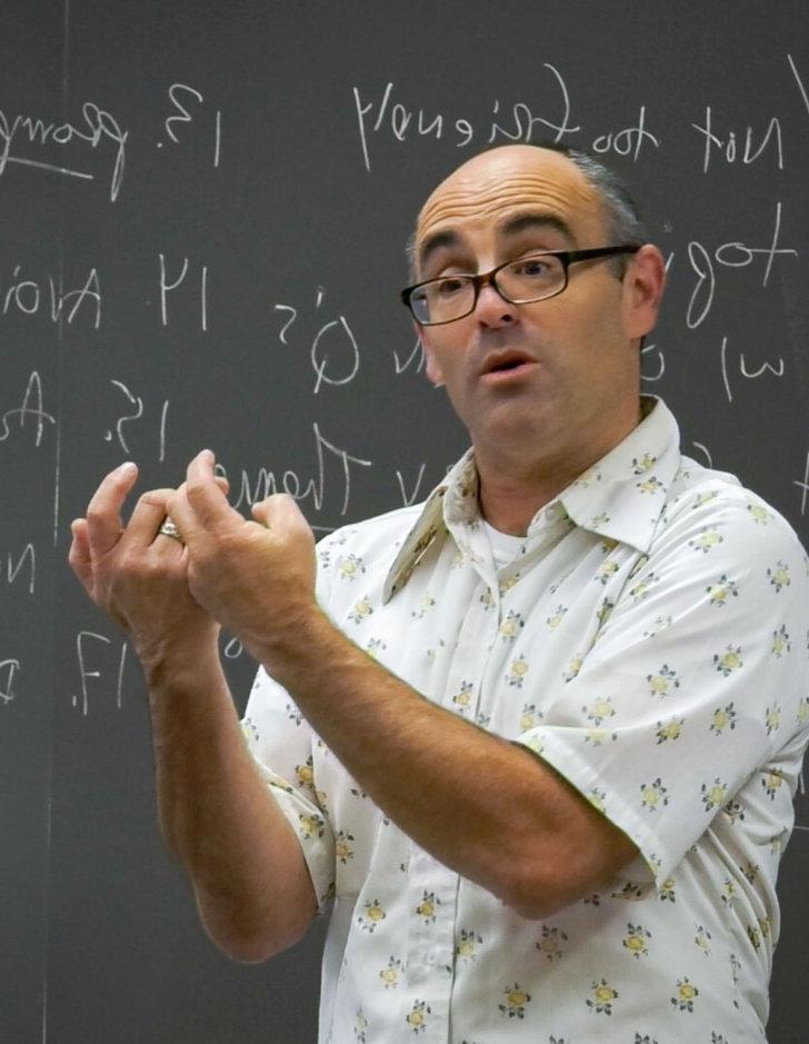 phil zuckerman lectures in a classroom while being filmed